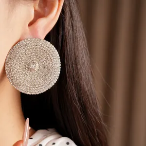 Primer plano de pendientes redondos grandes con incrustaciones de strass de lujo