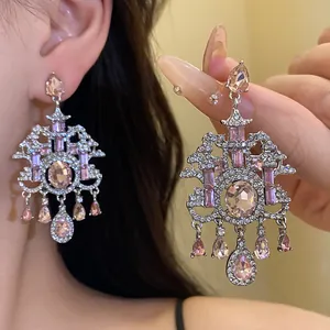 Dettaglio di orecchini vintage con cristalli rosa e complessa incastonatura d'argento