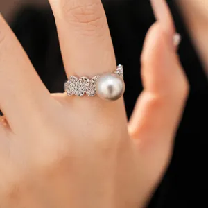 Detailed view of a silver-toned zircon-studded open ring with a large grey pearl