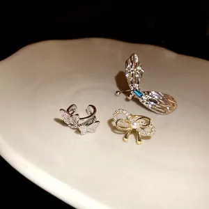 Exquisites Set aus silberner Zirkon-Schmetterling und goldener Perlen-Schleife Ohrklemmen
