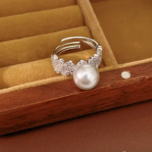Detailed close-up showing macro view of elegant white pearl and pave zircon open ring