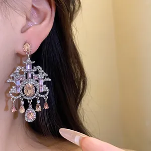 Dettaglio di orecchini pendenti vintage stile palazzo con pietre rosa e gocce