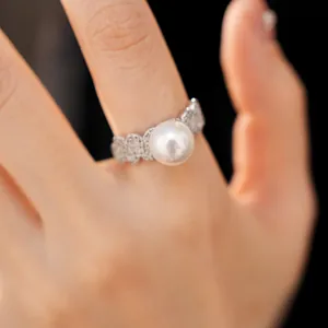 Detailed macro shot of a luxurious silver-toned ring featuring a large white pearl and pavé zircons