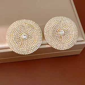 Primer plano de pendientes redondos grandes totalmente incrustados de strass brillante