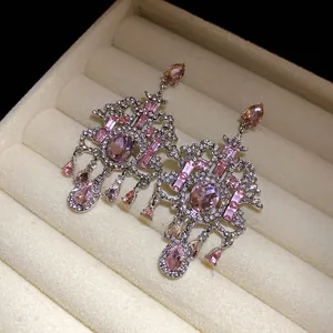 Vista macro dettagliata di orecchini vintage a lampadario con brillanti strass rosa vivaci