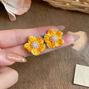 Elegant yellow enamel flower stud earrings with center pearl and sparkling zircon detail