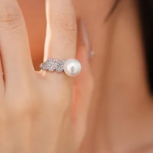 Detailed macro view of a stylish geometric zircon paved wave ring with a round white pearl