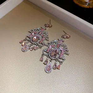 Vista dettagliata di orecchini vintage con cristalli rosa e decorazioni in strass lucidi.