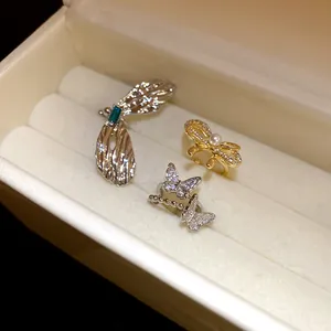 Makroansicht von Zirkonia-Schmetterling- und Perlenbogen-Ohrklemmen in einer Box