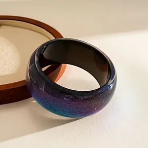 Detailed view of wide resin bangle featuring a vibrant blue and purple galaxy gradient