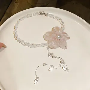 Elegant pearl necklace featuring a delicate pink chiffon flower and crystal teardrops.