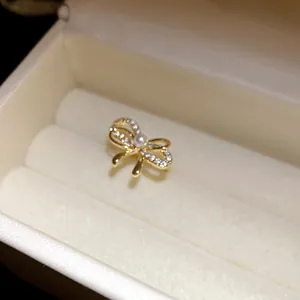 Makroansicht der goldfarbenen Schleifen-Ohrmanschette mit Zirkonia und Perle