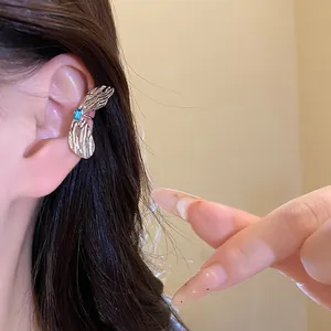 Exquisiter silberner Schmetterlingsohrring mit einem leuchtend blauen Zirkoniastein.