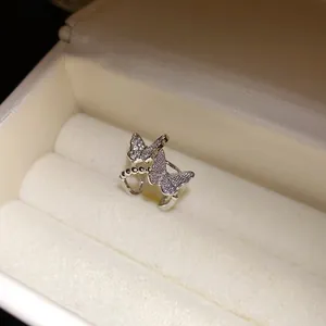 Detailansicht einer silberfarbenen Doppelschmetterlings-Ohrmanschette mit funkelnden Zirkonen.