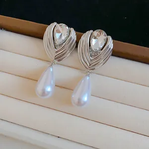 Detailed view of French style rhinestone teardrop pearl earrings in silver finish