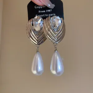 Close-up of French vintage water drop pearl earrings with sparkling rhinestones