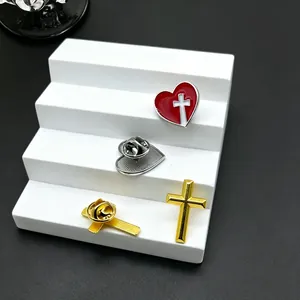 Vintage Emaille-Herz- und Goldkreuz-Anstecknadeln auf einem weißen Ständer.