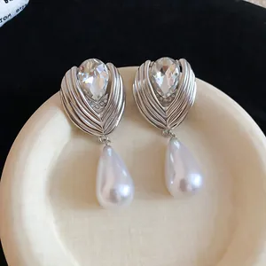 Detailed macro view of French style rhinestone silver drop earrings with elegant teardrop pearl