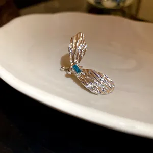 Exquisites Detail der silbernen Schmetterlings-Ohrklemme mit einem blauen Zirkonstein