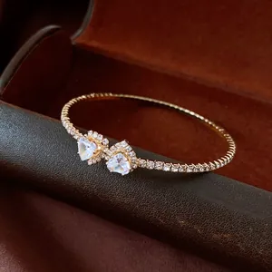 Detailed close-up of gold-plated heart-shaped diamond bangle with premium crystal accents