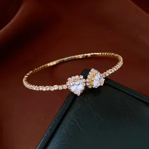 Close-up of golden open bracelet with sparkling rhinestones and heart-shaped crystals