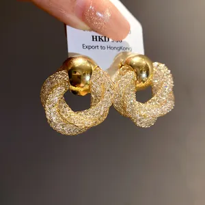 Close-up of elegant vintage golden mesh twisted hoop earrings shown on a display tag