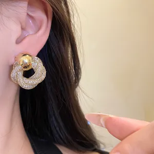 Detailed macro view of luxury vintage golden mesh twisted flower stud earrings worn on ear