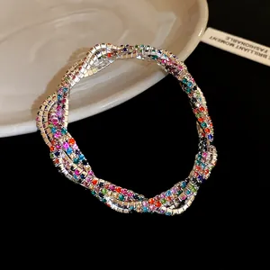 Close-up macro view of multi-layered silver-tone bracelet with vibrant colorful rhinestones.