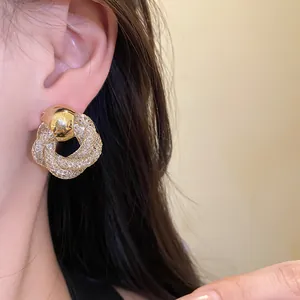 Close-up of vintage gold mesh flower stud earrings worn by a model in a lifestyle setting