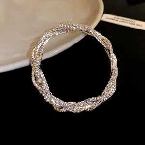 Close-up of a silver-toned multilayer rhinestone wrap bracelet with twisted design