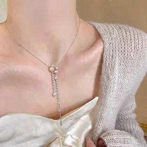 Close-up of elegant silver necklace with pearls and sparkling cubic zirconia dangles