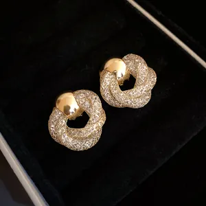 Close-up of gold vintage twisted flower mesh stud earrings with sparkling crystals.
