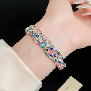 Detail view of a luxury multi-layer braided bracelet with colorful rhinestones on wrist