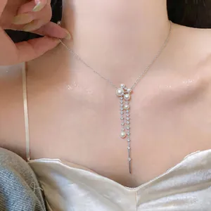 Detailed view of elegant French style pearl and zircon tassel necklace on model