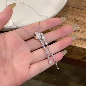 Detailed view of a French style silver necklace with pearls and sparkling cubic zirconia
