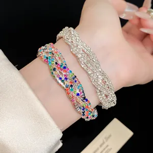 Close-up detail showing silver and colorful multi-layer rhinestone twisted bracelets on wrist.