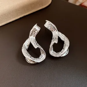 Primer plano de pendientes geométricos plateados con un acabado de metal líquido único