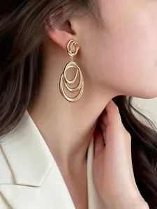 Close-up of elegant gold multi-layered ring dangle earrings worn by an Asian model