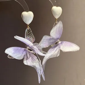 Elegant purple fabric butterfly earrings with white heart studs in a romantic style.