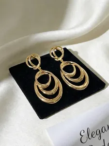 Close-up of golden multi-layer circular drop earrings with elegant minimalist design