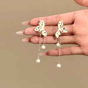 Detailed close-up of sweet colorful polka dot flower earrings featuring long elegant pearl tassels