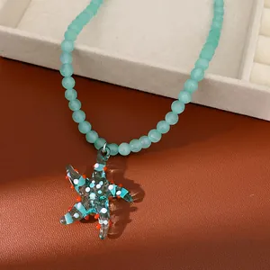 Detailed macro view of a handmade glass starfish pendant on a mint green beaded necklace chain
