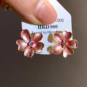 Macro detail of elegant pink flower stud earrings featuring a brilliant zircon center stone