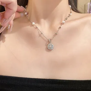 Macro view of dainty silver necklace with pearls and zircon star compass pendant on neck