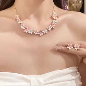 Elegant pink and white flower jewelry set featuring a necklace and stud earrings