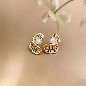 Primo piano dettagliato di orecchini a perno con perle e oro 18K dal design scavato