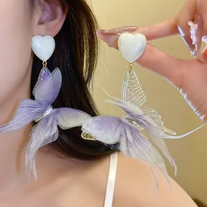 Detailed view of elegant purple fabric butterfly drop earrings with white heart detail