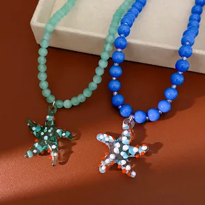 Close-up detail showing the texture of glass beaded starfish necklaces in blue and green