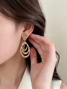 Detailed close-up showing gold multi-layered circular dangle earrings on an Asian model