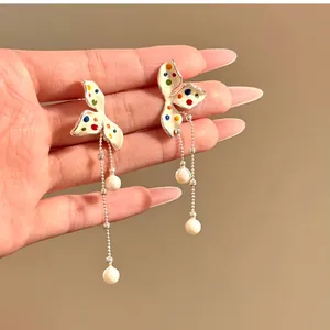 Detailed shot of elegant flower tassel earrings with colorful polka dots and pearl drops